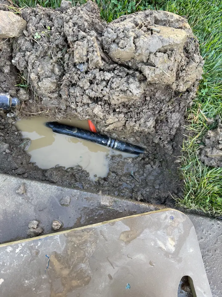 A buried water line exposed in a wet hole with a new repair coupling